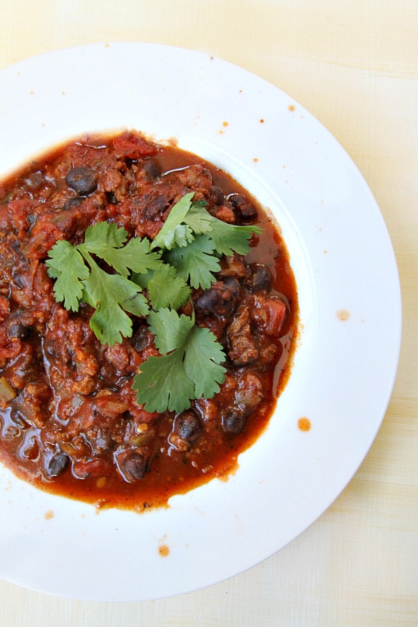 Black Bean Turkey Sausage Chili in a white bowl with cilantro garnish