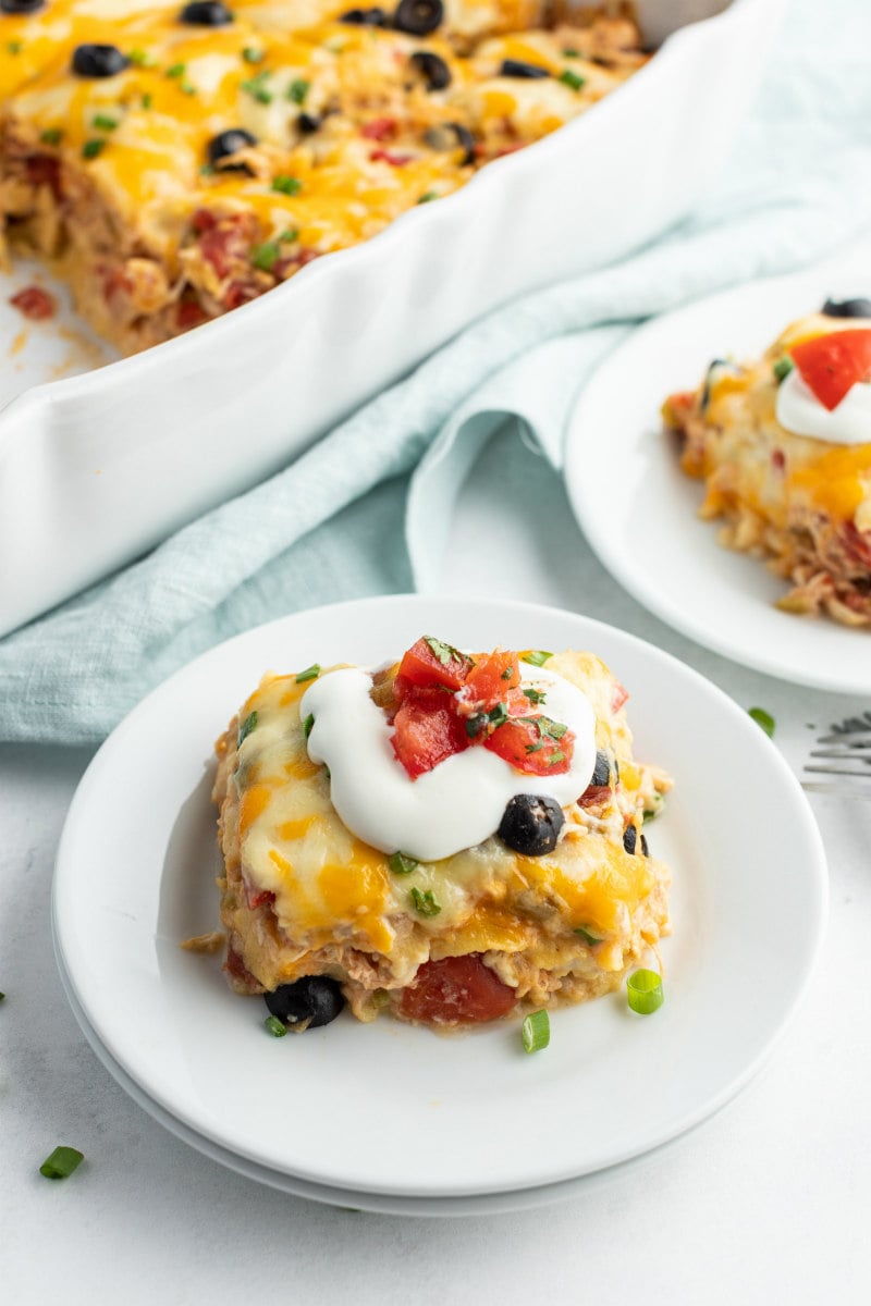 Chicken Enchilada Casserole recipe from RecipeGirl.com #chicken #enchilada #casserole #recipe #RecipeGirl serving of chicken enchilada casserole on white plate
