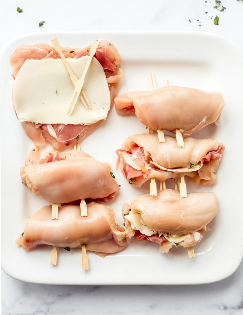 process showing how to assemble chicken saltimbocca with chicken, cheese, other ingredients and sandwich pick