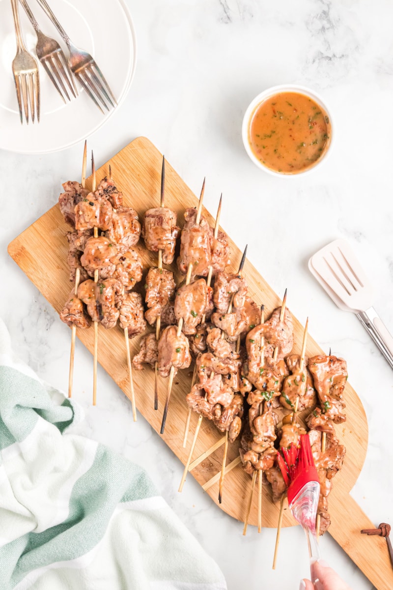coconut curry pork satay skewers on board with brushing sauce