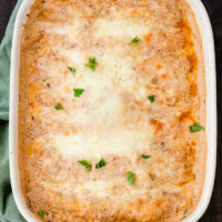 creamy chicken enchiladas in white casserole dish