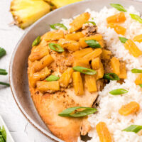 crockpot pineapple chicken on plate with rice and pineapple tidbits