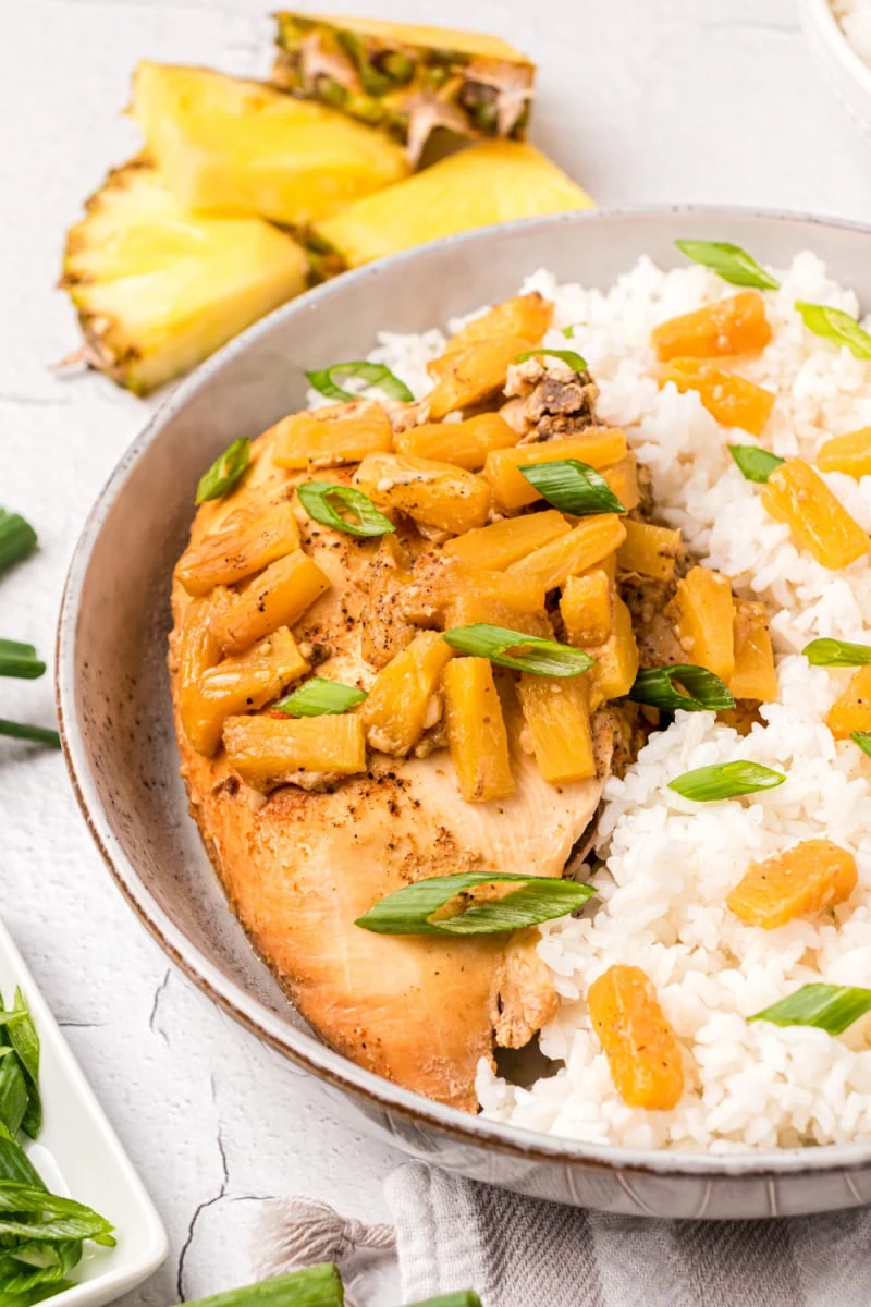 crockpot pineapple chicken on plate with rice and pineapple tidbits