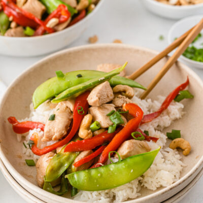 bowl of chicken stir fry with chopsticks