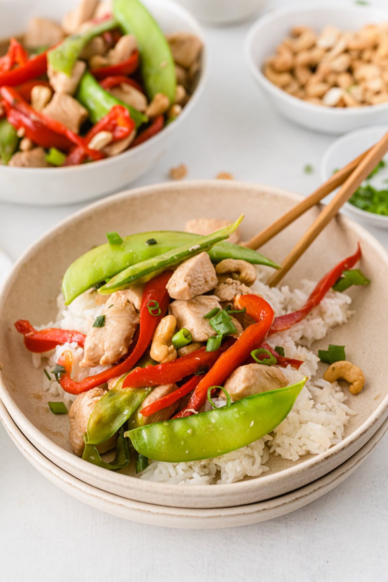 bowl of chicken stir fry with chopsticks