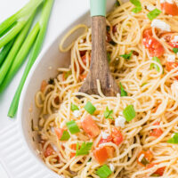 greek spaghetti in a serving dish with spoon