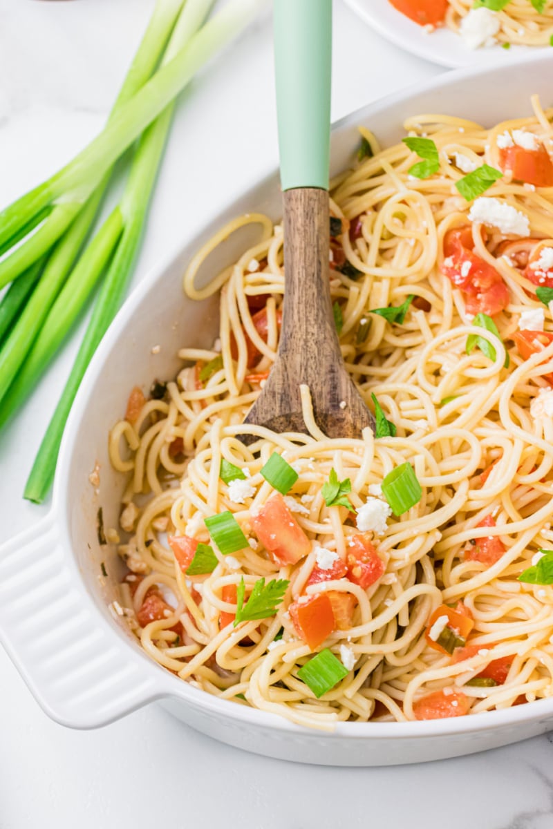 greek spaghetti in a serving dish with spoon