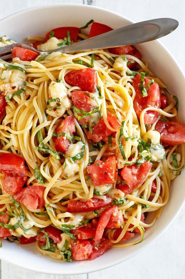 overhead shot of Linguine with Tomatoes Basil and Brie in a white bowl with a fork