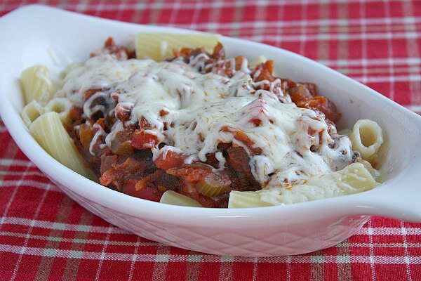 Pasta with Garden Bolognese Sauce in a white dish on a red plaid tablecloth