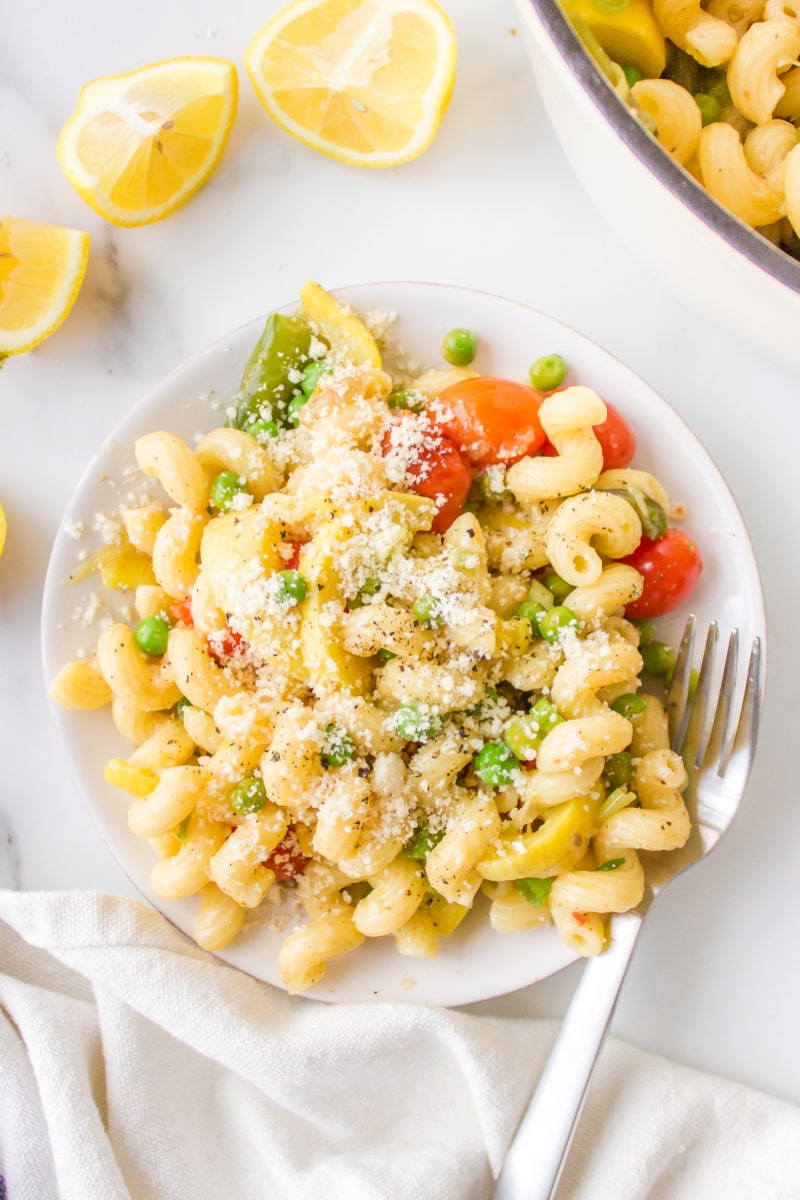 pasta with spring vegetables topped with Parmesan on a plate