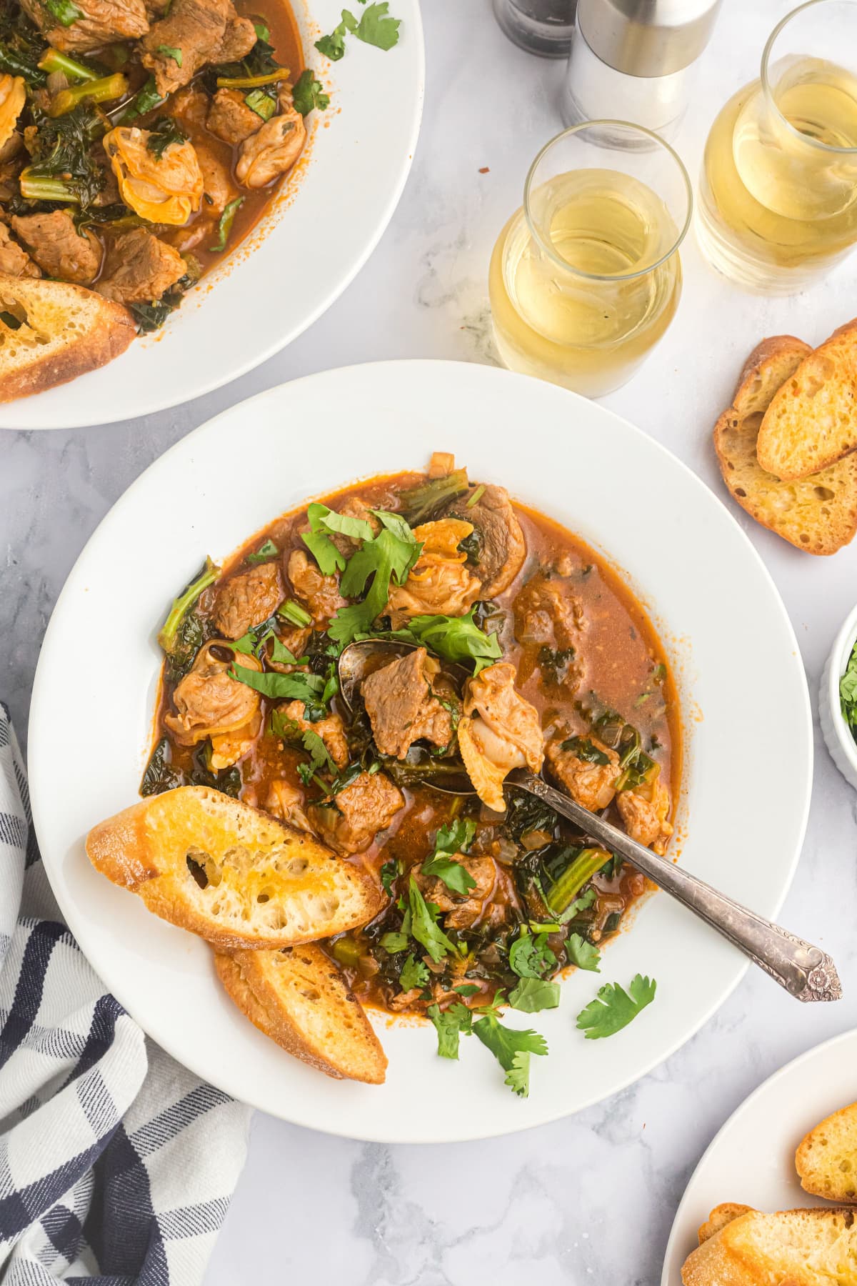 bowl of pork stew with baguette