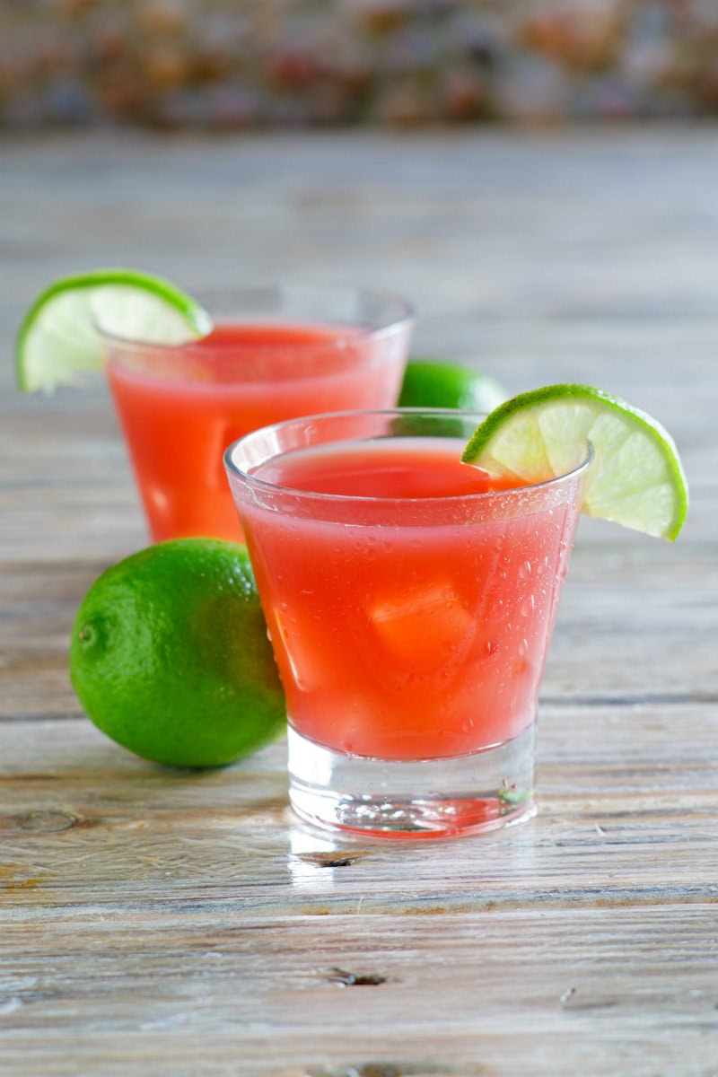 two Sea Breeze Cocktails garnished with lime wedges