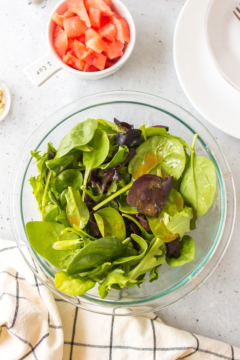 bowl of lettuce tossed in dressing