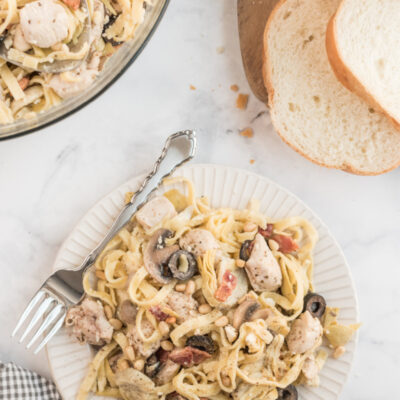 serving of pasta on white plate with fork