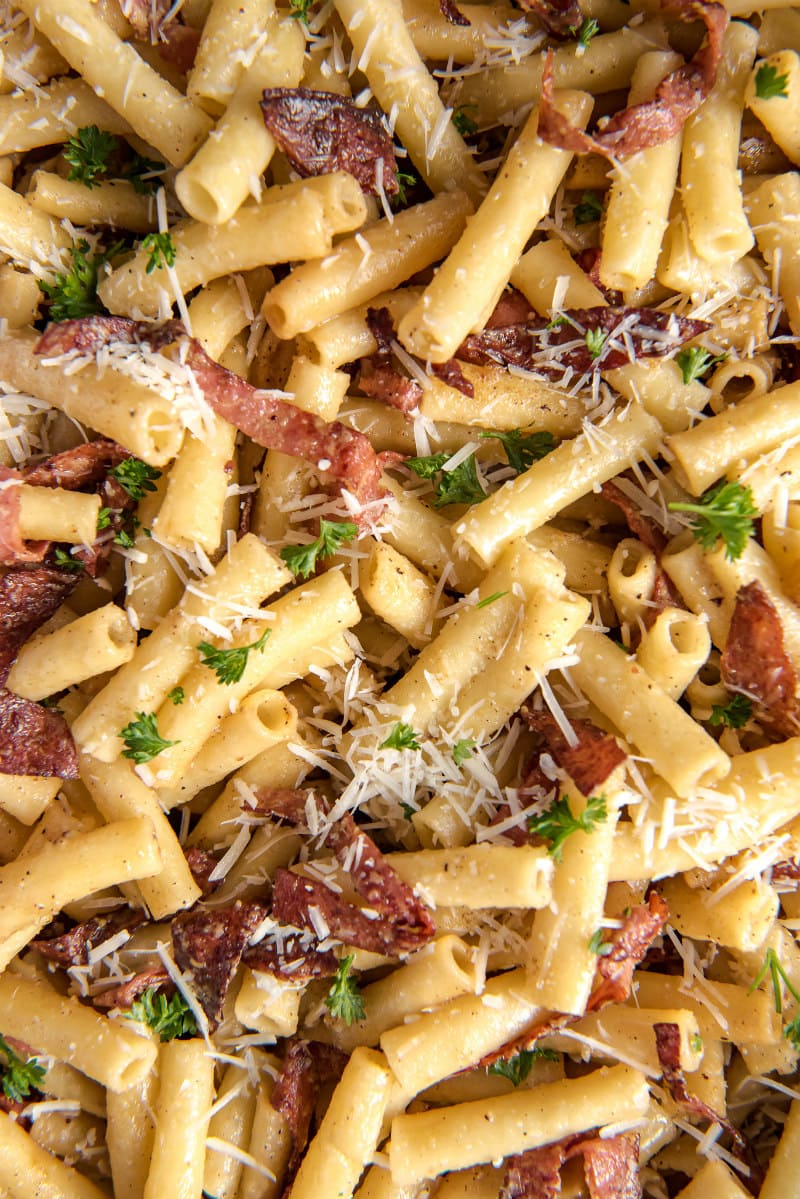 close up of ziti carbonara with salami