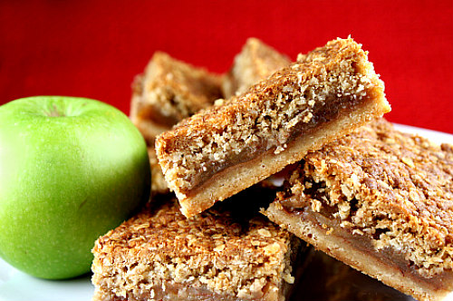 Apple Pie Bars stacked with a green apple