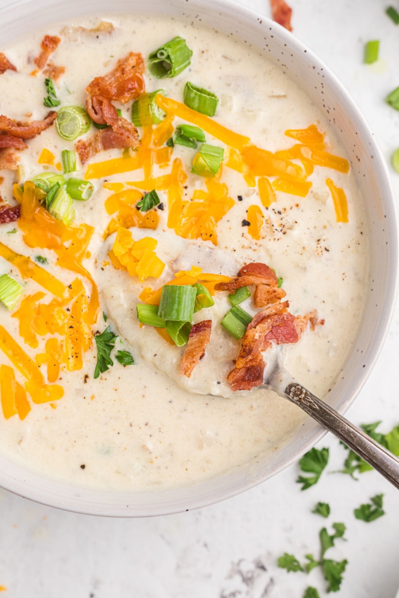 baked potato and bacon soup in bowl with spoon