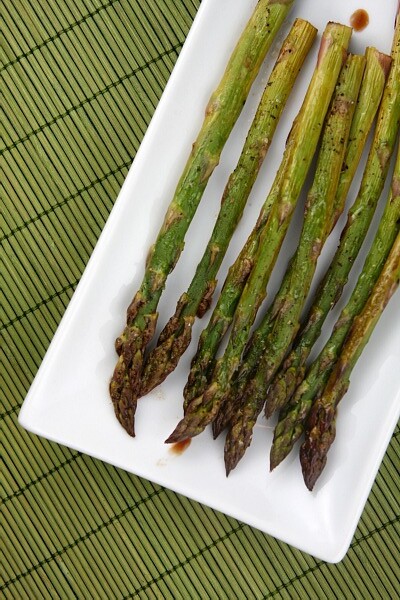 asparagus on a white platter with green background