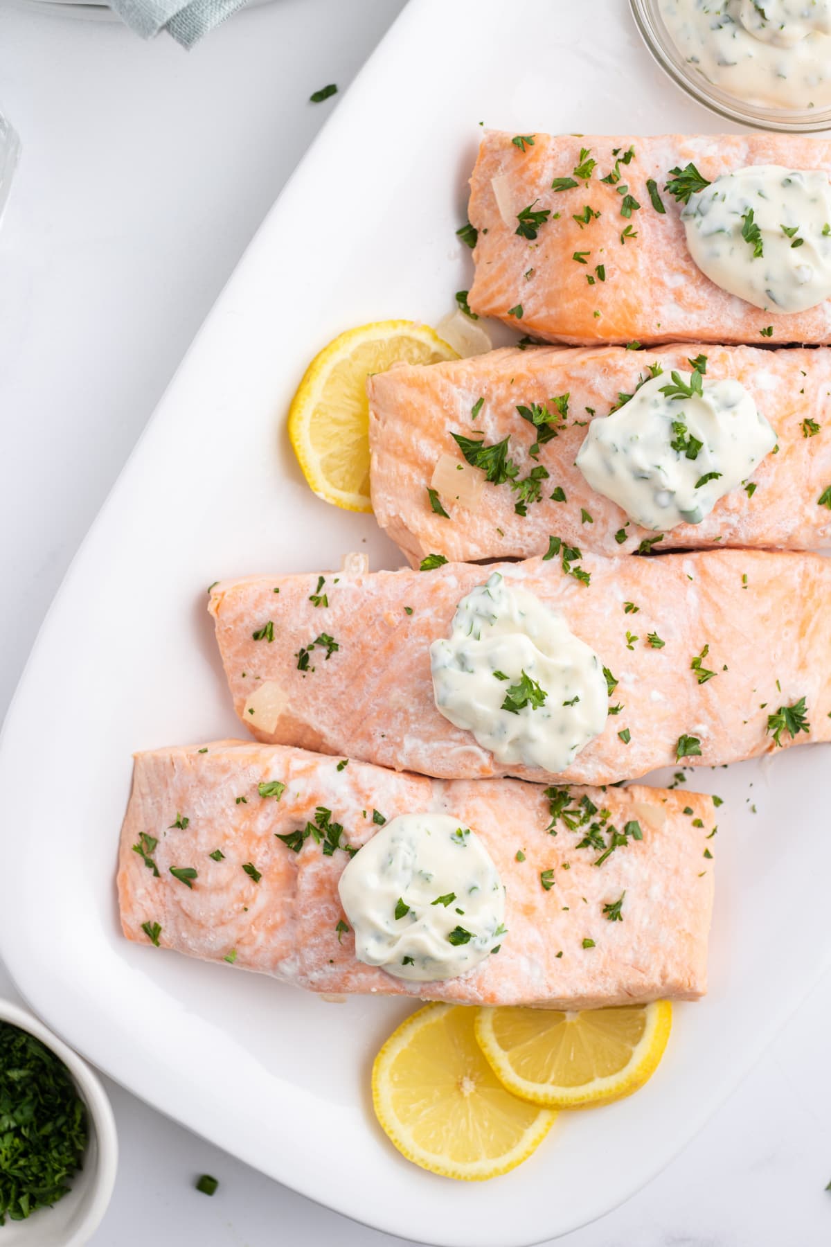beer poached salmon filets on a platter topped with tarragon mayonnaise