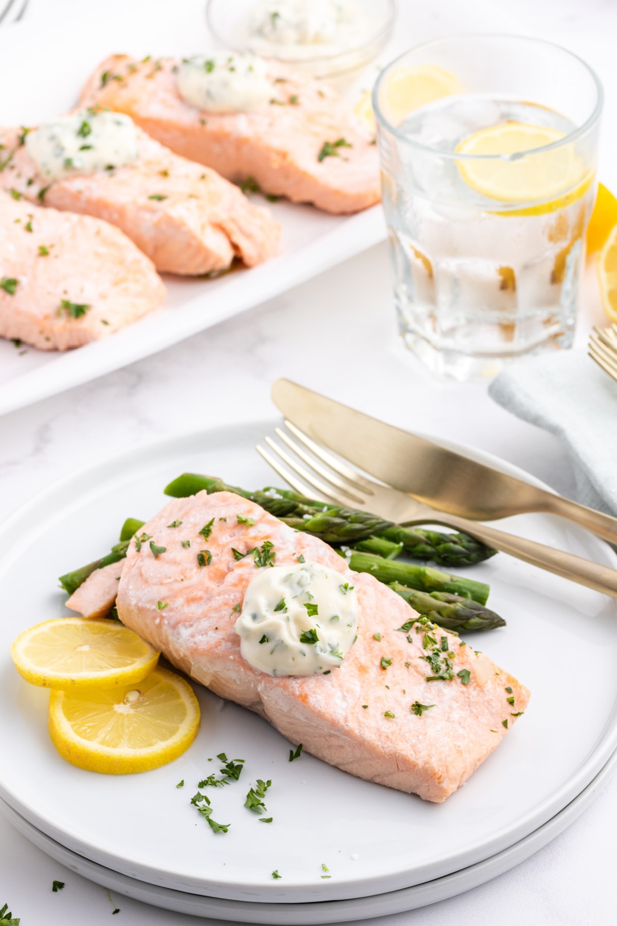 beer poached salmon filet topped with tarragon mayonnaise on a plate