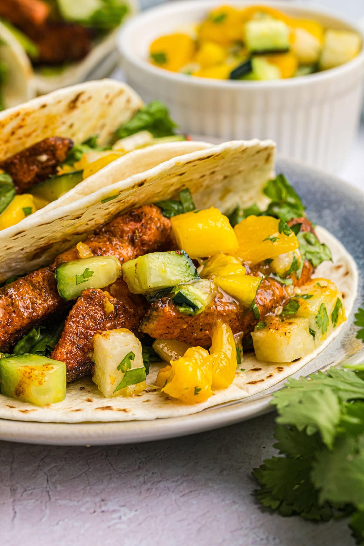 Blacked Salmon Tacos with Mango Salsa recipe from RecipeGirl.com : fish tacos close up blackened salmon tacos on plate