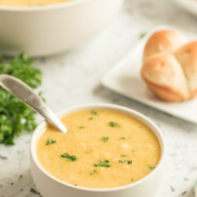 butternut squash soup in white bowl with spoon