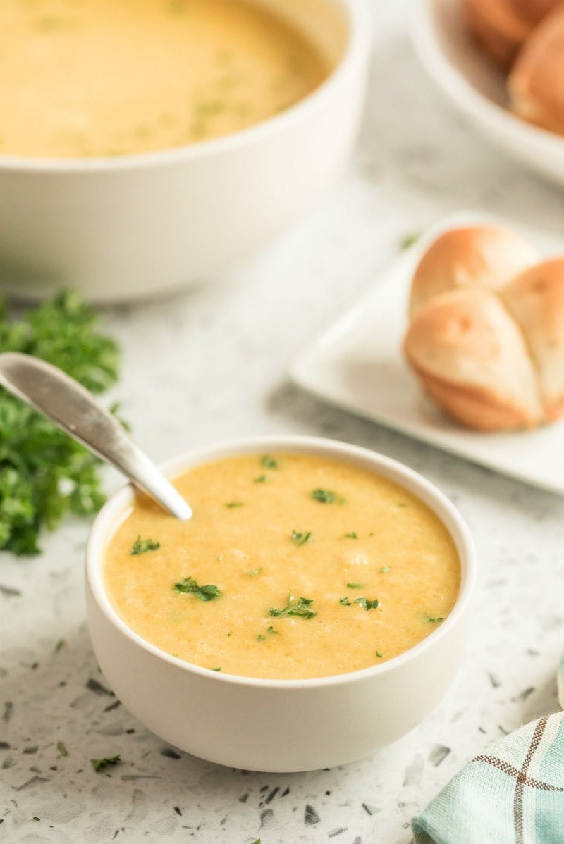 butternut squash soup in white bowl with spoon