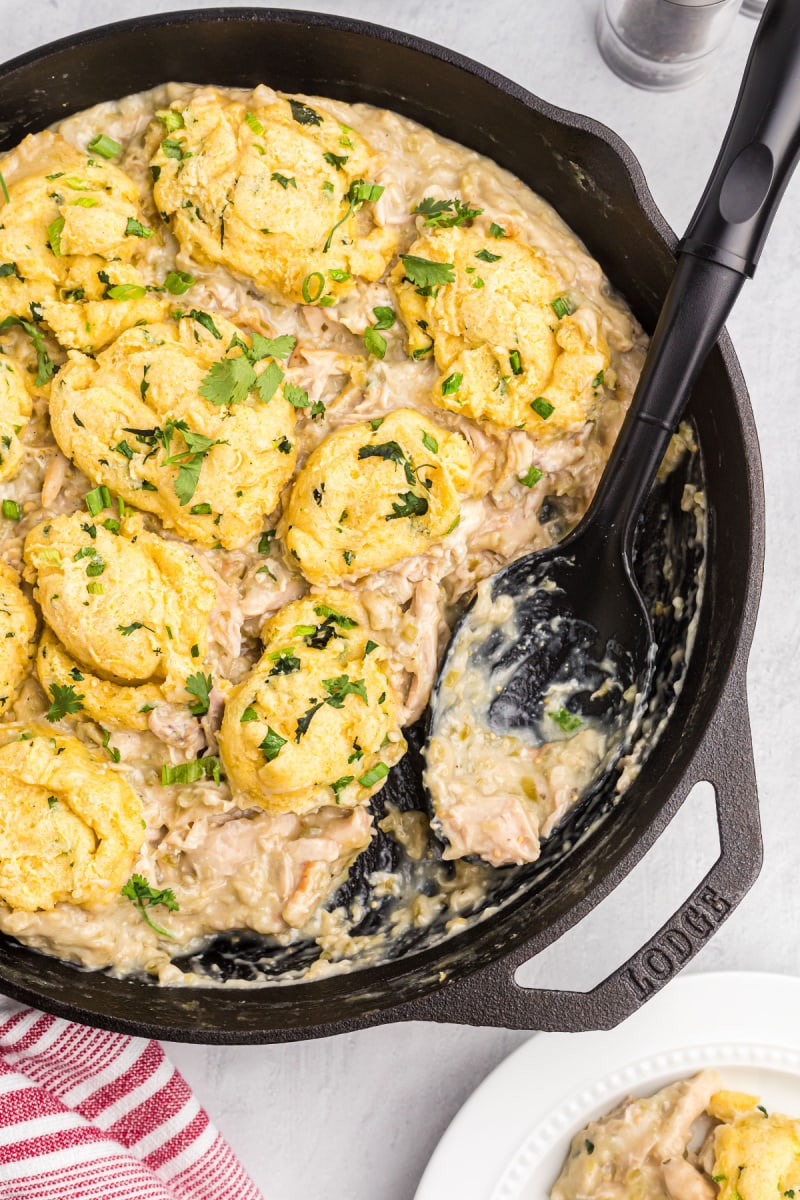 chicken salsa verde in a cast iron skillet with a serving scooped out of it