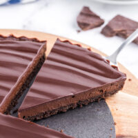 chocolate tart with slice being taken out of it