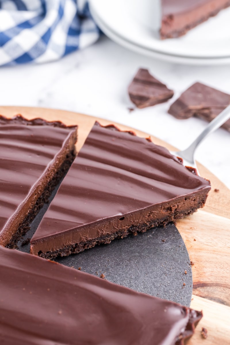 chocolate tart with slice being taken out of it