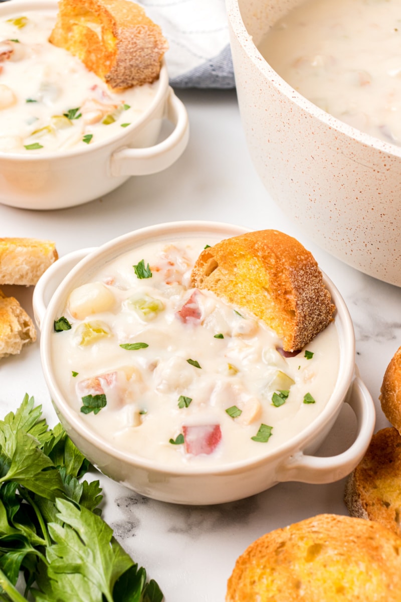 bowl of clam chowder with hunk of bread sitting in it