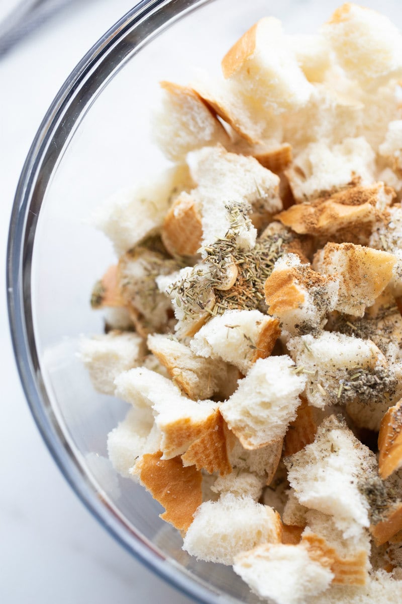 bread cubes with seasoning in glass bowl