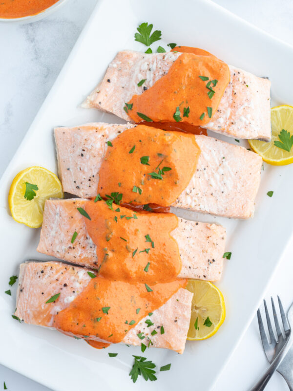 four pieces of cold poached salmon with mustard sauce on top