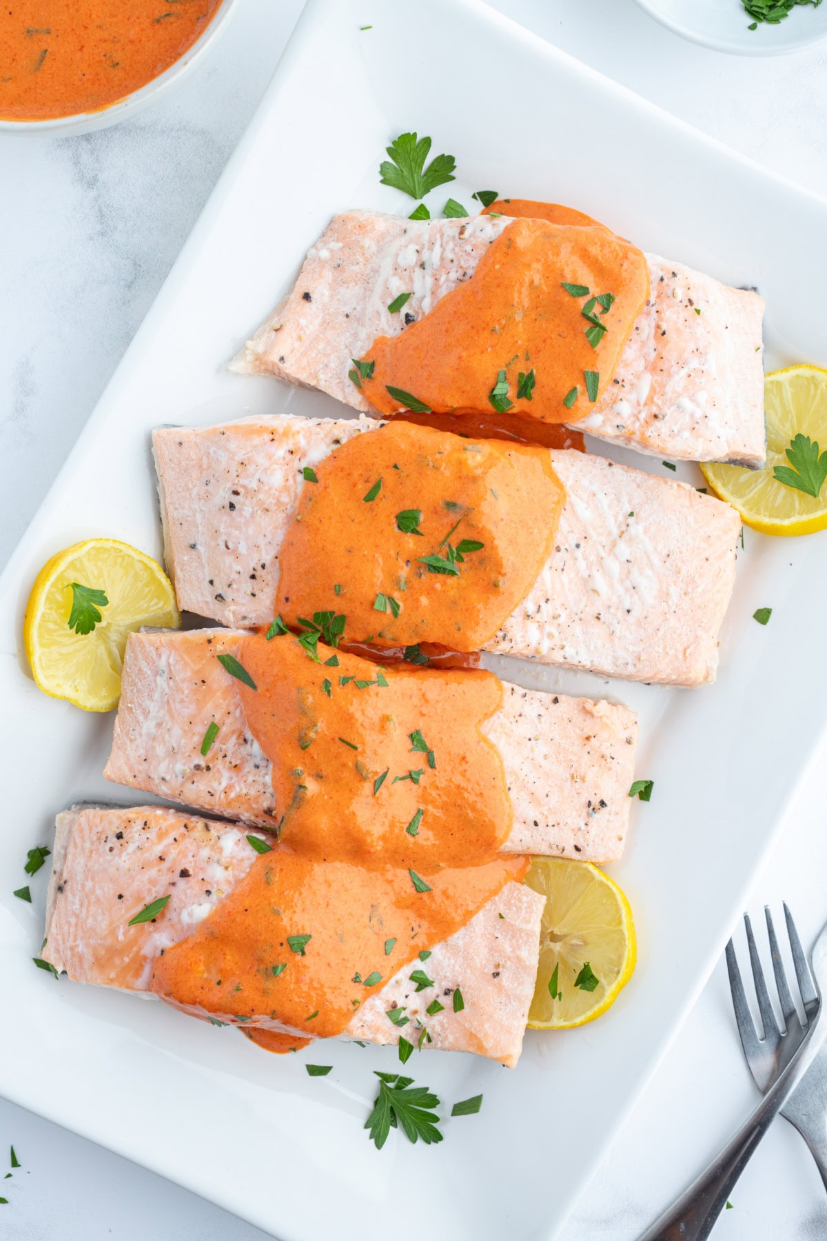 Cold Poached Salmon with Roasted Red Pepper and Mustard Sauce recipe from RecipeGirl.com four pieces of cold poached salmon with mustard sauce on top