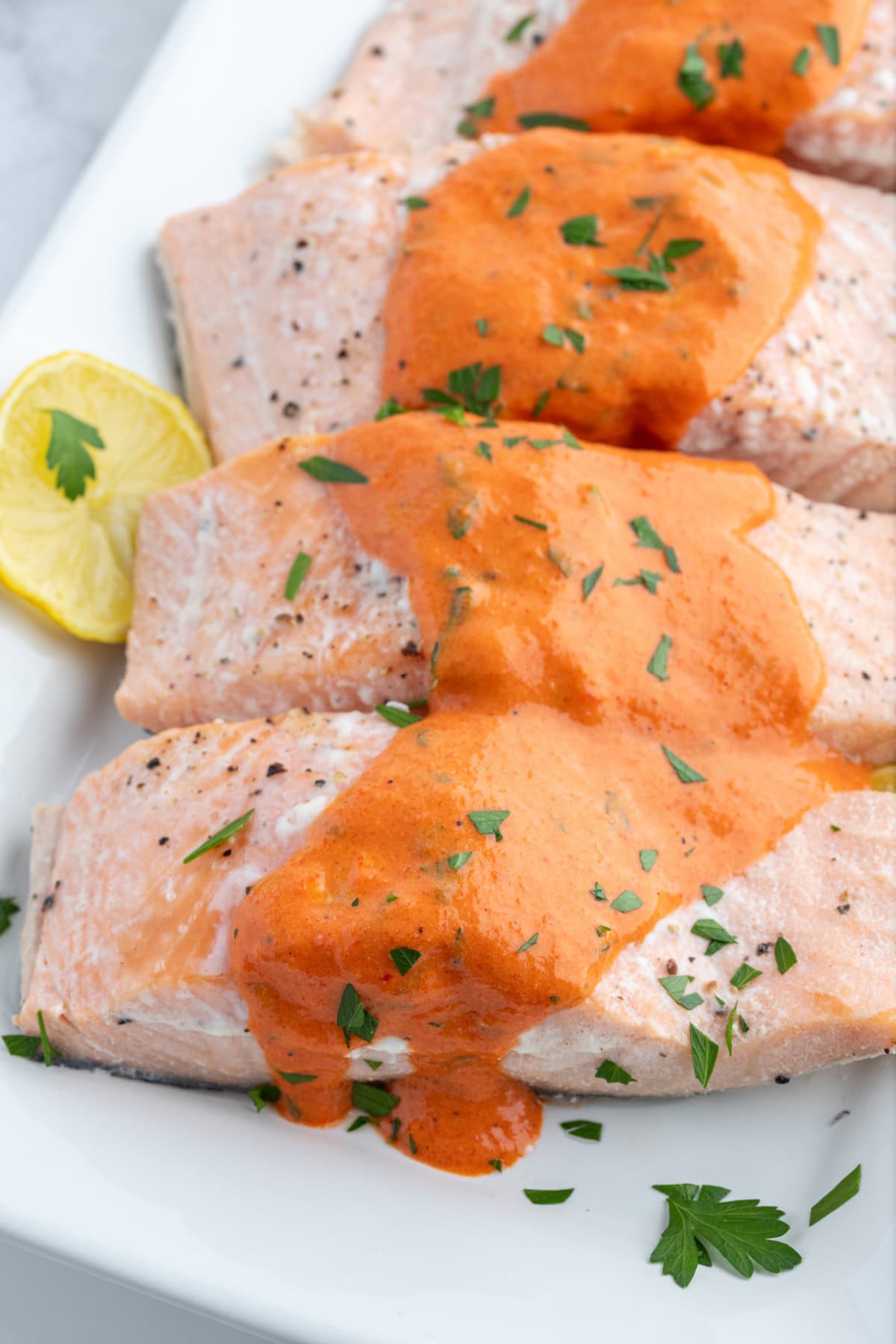 Cold Poached Salmon with Roasted Red Pepper and Mustard Sauce recipe from RecipeGirl.com several salmon filets with mustard sauce on top