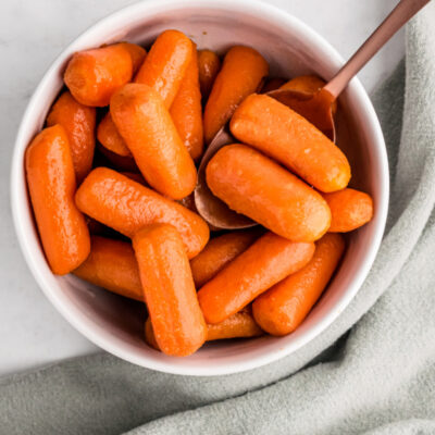 bowl of glazed carrots with a spoon