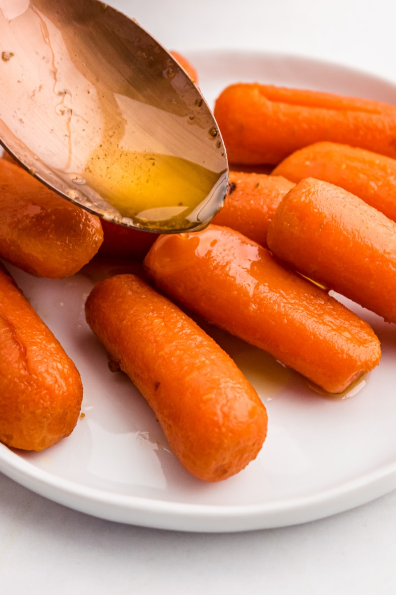 spooning glaze onto baby carrots