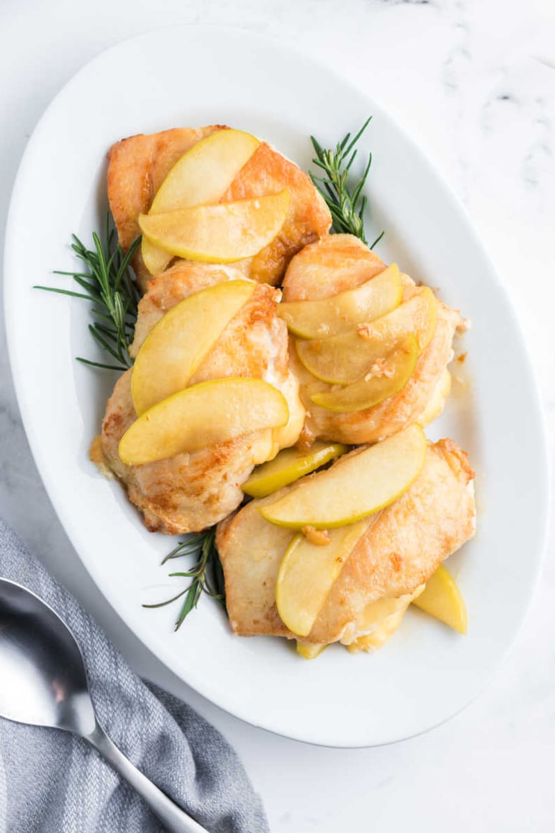 gouda stuffed chicken with apples on a white platter