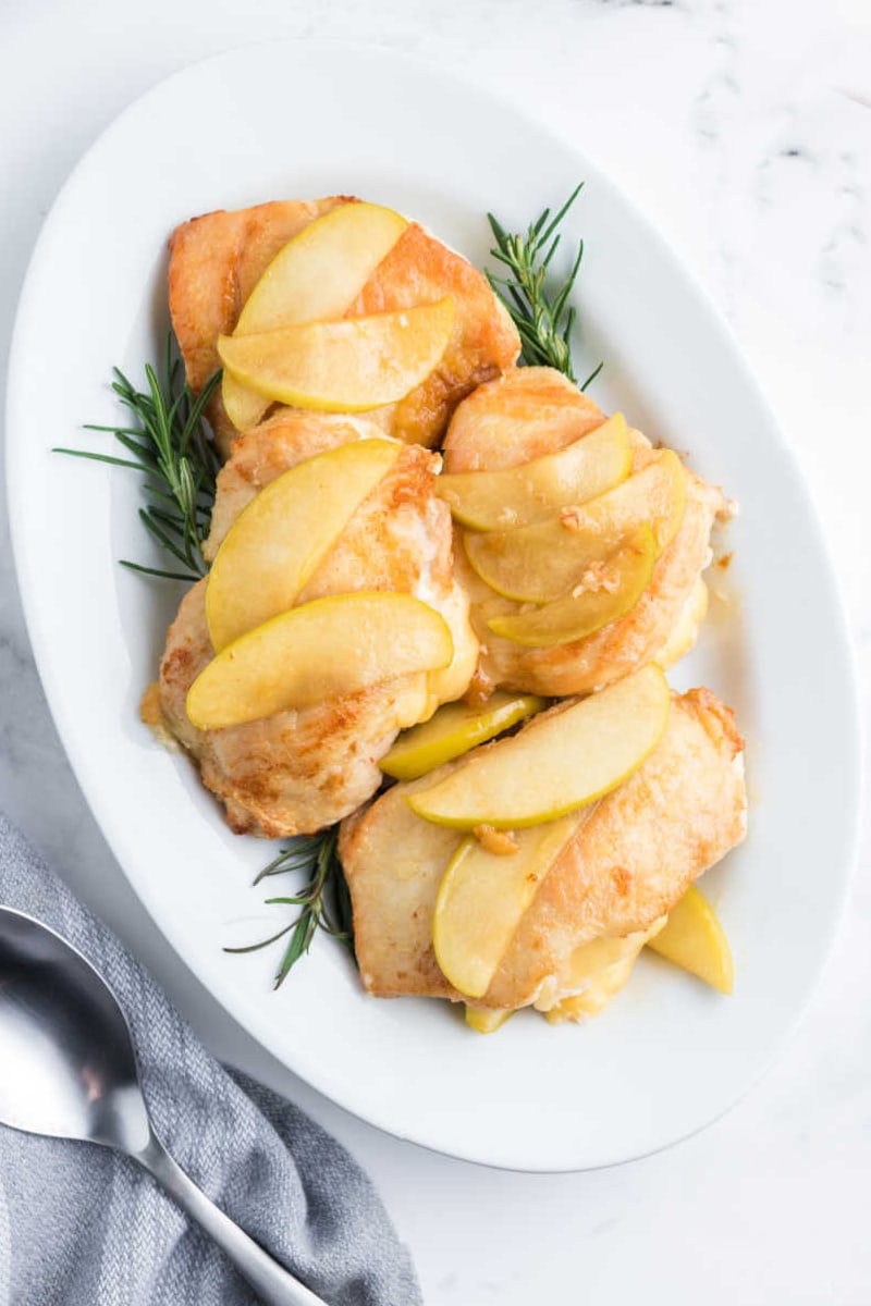 gouda stuffed chicken with apples on a white platter