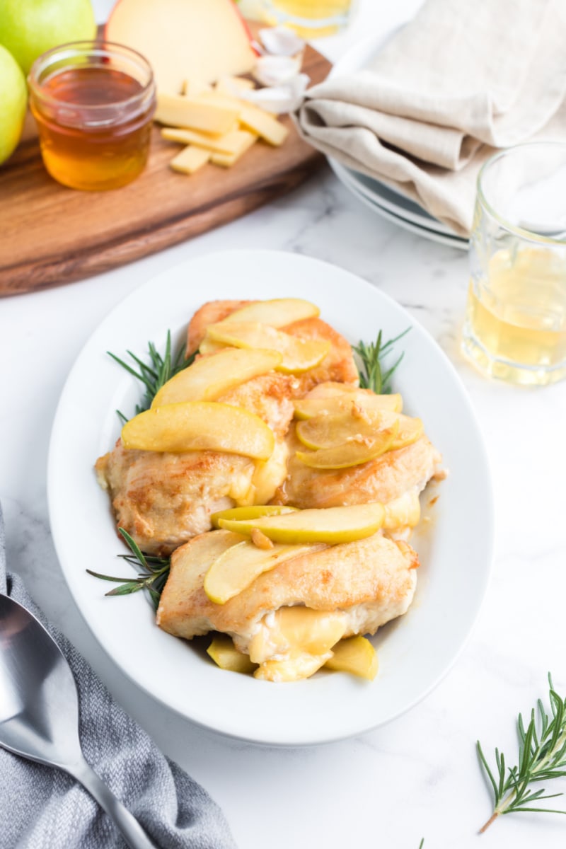 gouda stuffed chicken with apple pan sauce on a white platter