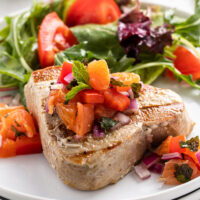 grilled tuna with citrus salsa on a plate with salad