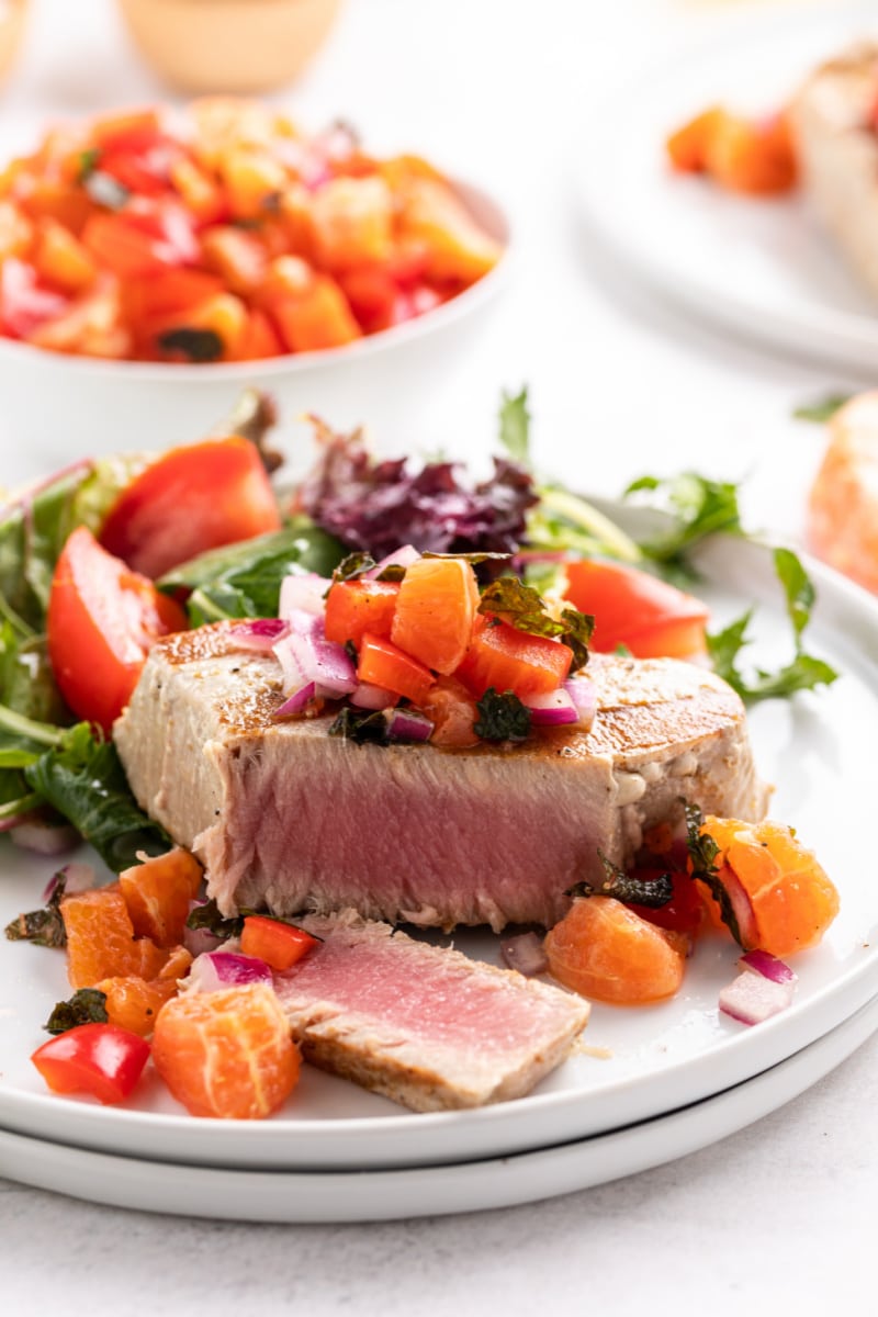 sliced grilled tuna with citrus salsa on a plate with salad