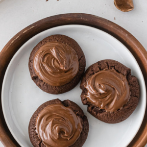 three nutella thumbprint cookies on a plate