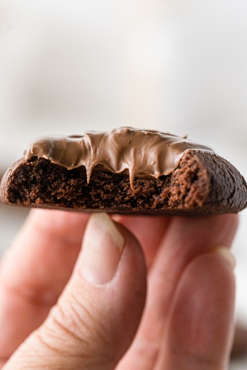 hand holding nutella thumbprint cookie with bite out of it