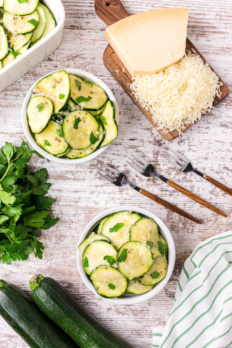 two serving dishes of parmesan zucchini slices