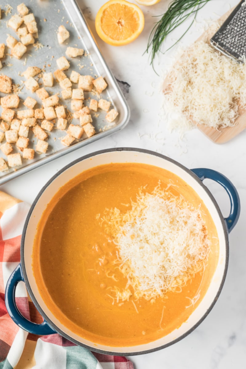 pumpkin soup in a pot with cheese on top