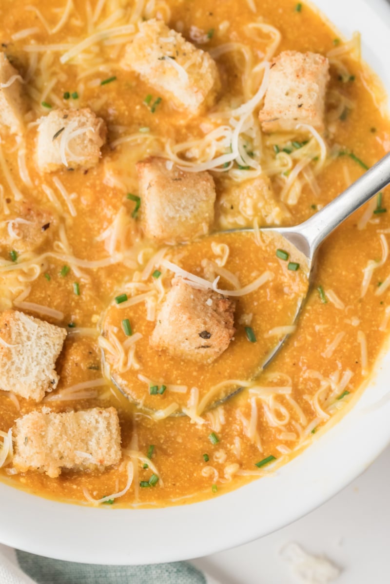 white bowl of pumpkin soup with croutons