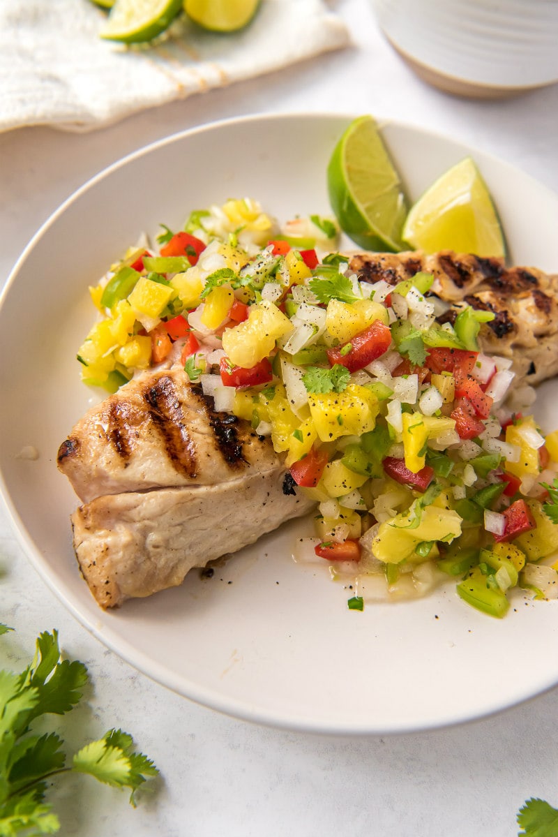 red snapper with pineapple salsa on a white plate