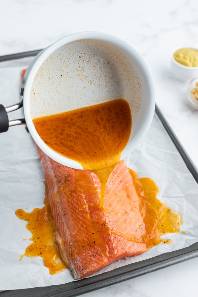 mustard marinade pouring onto salmon