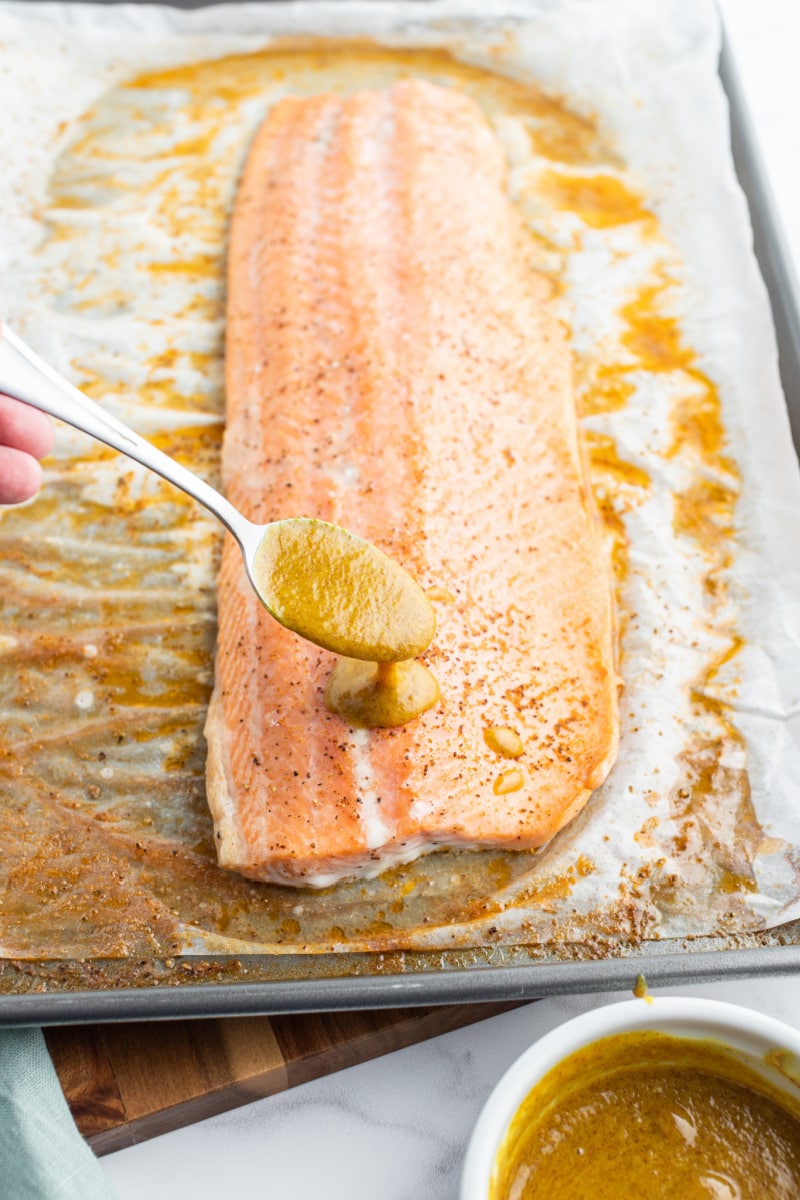 spooning sauce onto salmon